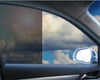 View through a car window with half 35% VLT static cling film and half clear, showing cloudy sky.